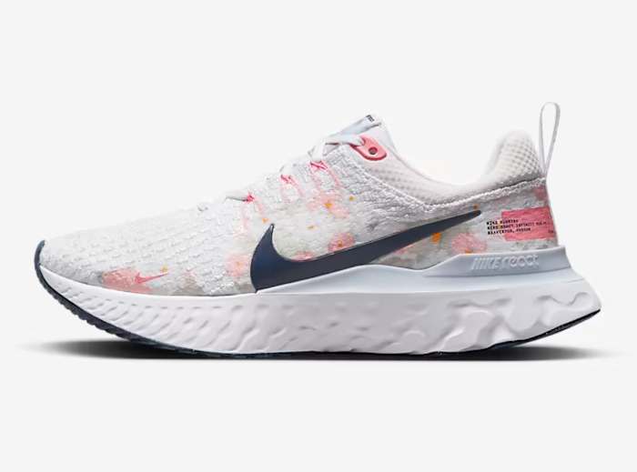 Side view of white and Navy Nike shoe.